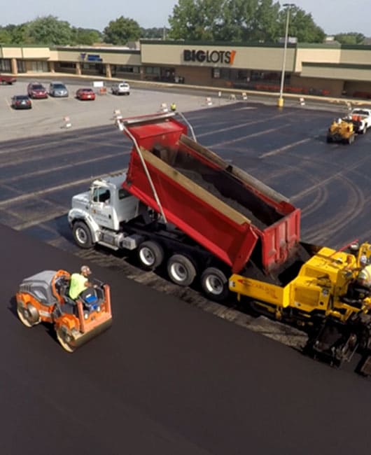 Site Services crew with equipment repaving a BigLots parking lot