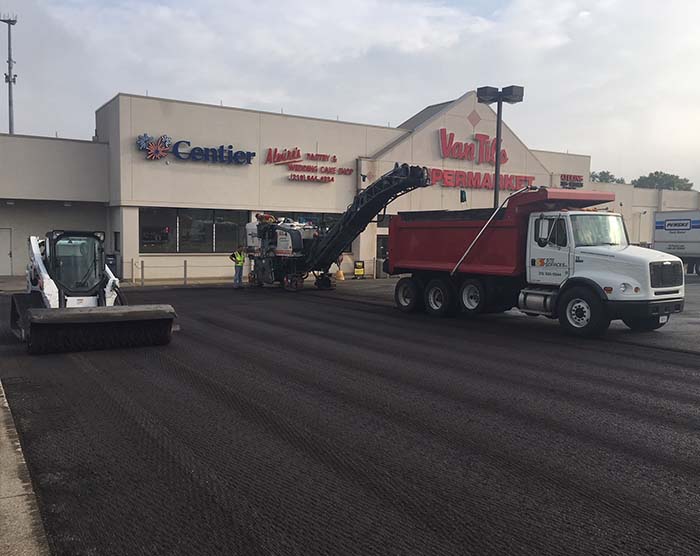 Site Services crew with equipment repaving a supermarket parking lot