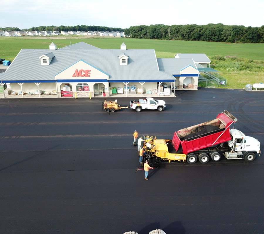 Site Services crew and machinery paving Ace Hardware parking lot