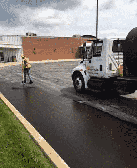Site Services crew with oil truck top-coating parking lot