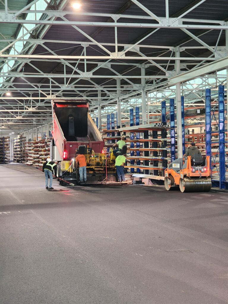Site Services | A large warehouse with workers working on the floor.