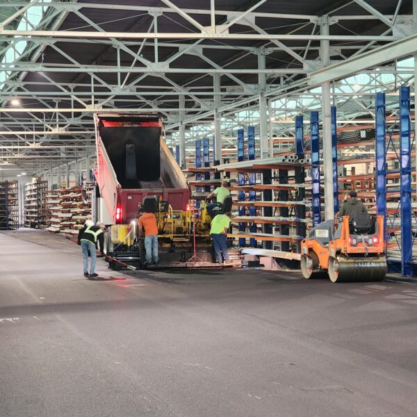 Site Services | A large warehouse with workers working on the floor.