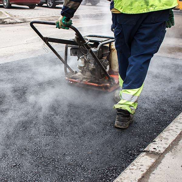 Crew & equipment completing asphalt patching