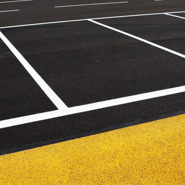 Site Services | Close-up of a commercial parking lot with white and yellow striping.