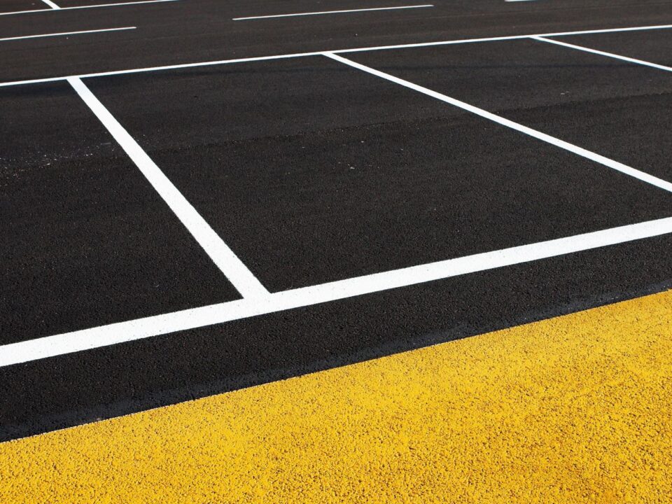 Site Services | Close-up of a running track with white lane markings and a textured yellow starting block.