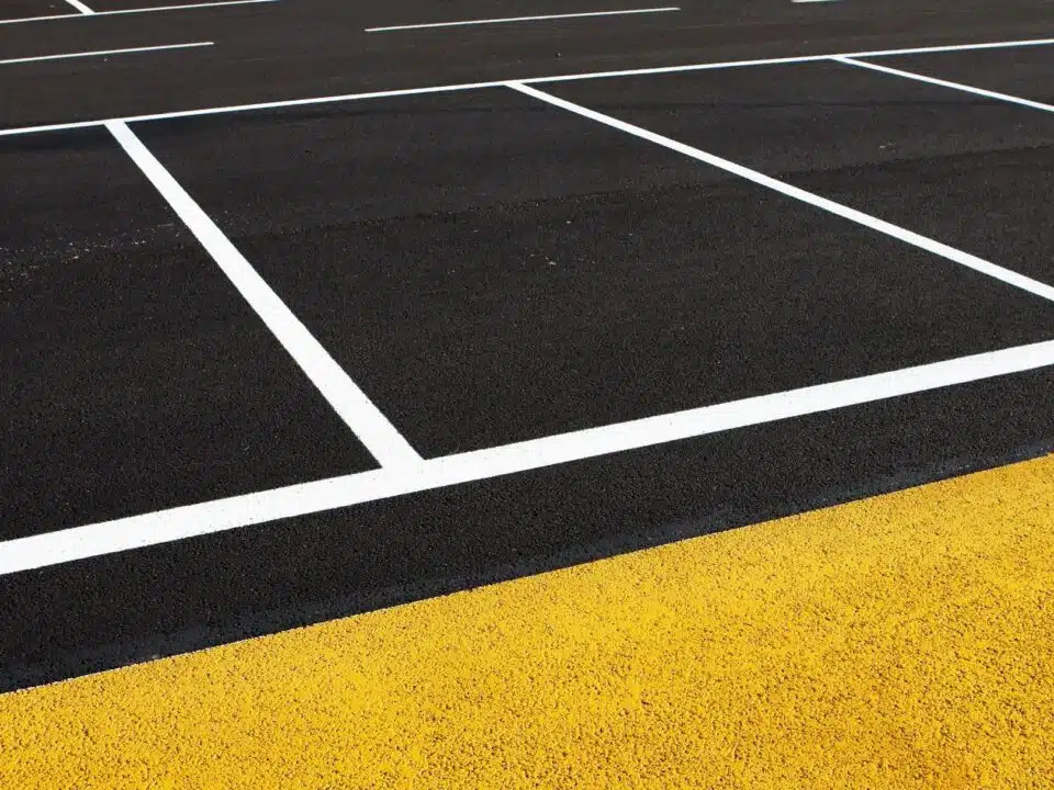 Site Services | Close-up of a commercial parking lot with white and yellow striping.