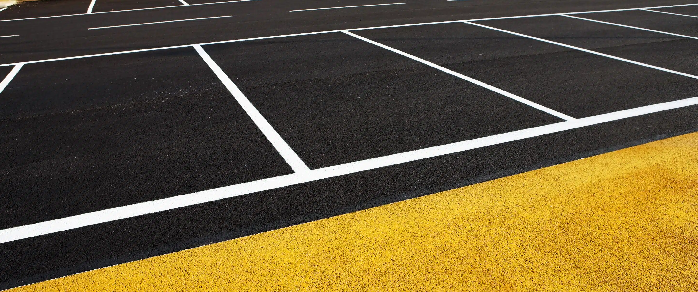 Site Services | Close-up of a commercial parking lot with white and yellow striping.