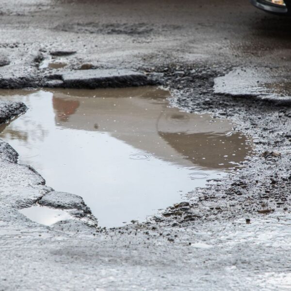 Site Services | Pothole in a commercial parking lot filled with water.