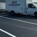 Site Services | A white "Site Services" truck parked on a newly paved and marked asphalt surface. The truck is attached to a white trailer.