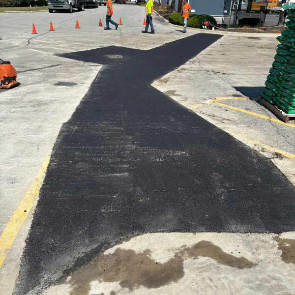 A freshly patched asphalt section on a parking lot.