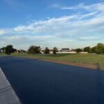 Site Services | A road with grass and trees in the background.