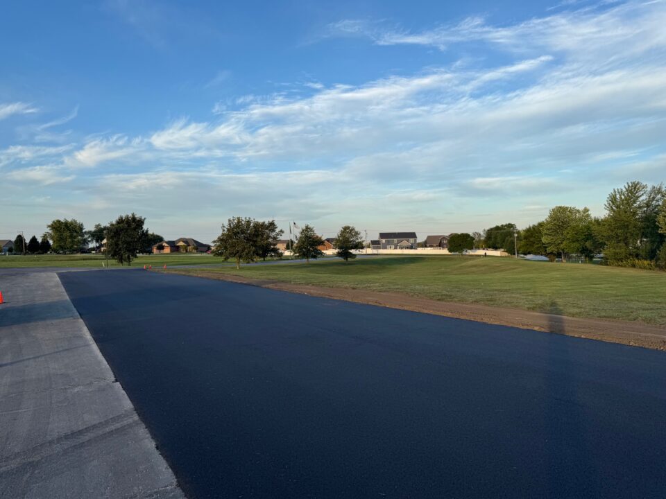 Site Services | A road with grass and trees in the background.